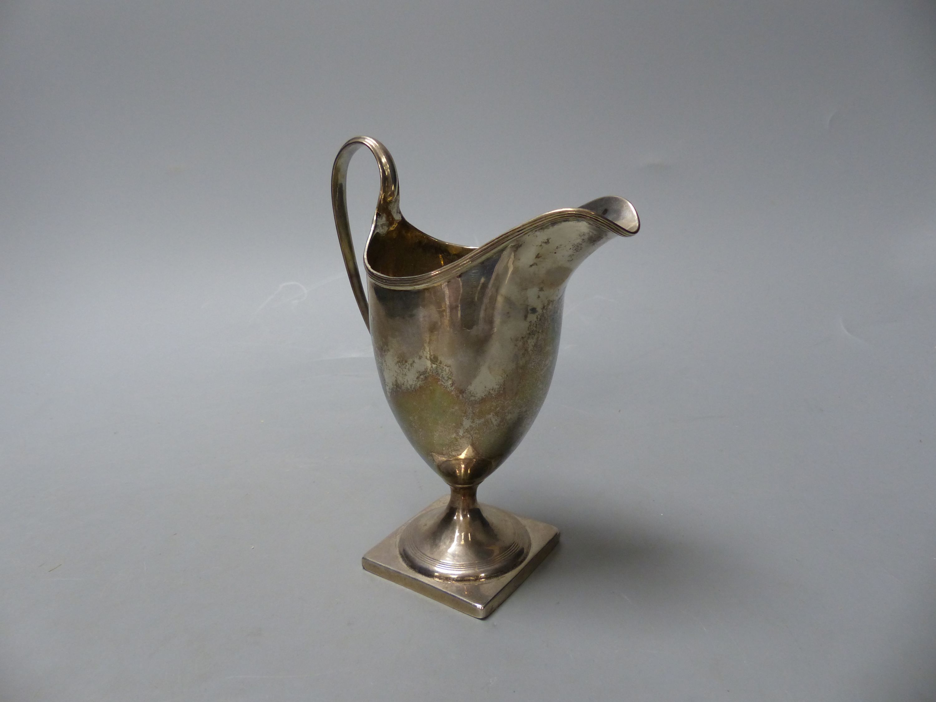 A George III silver helmet shaped cream jug, I.B, London, 1800, 14.9cm